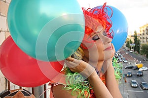 Dreaming Girl in colorful wig with balloons
