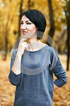 Dreaming girl portrait, yellow leaves on background, autumn city park, fall season