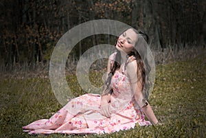 Dreaming girl who is sitting on the grass