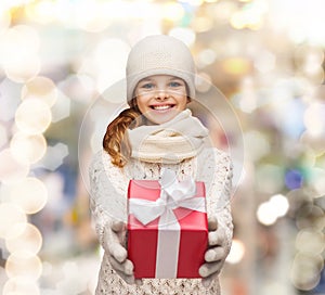 Dreaming girl in winter clothes with gift box