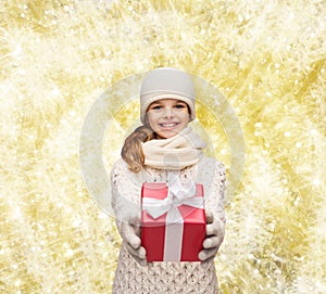 Dreaming girl in winter clothes with gift box