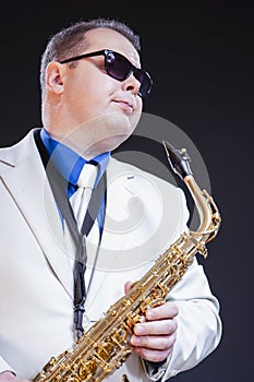 Dreaming Male Saxophonist Posing In Sunglasses With Sax