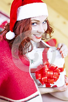 Dreaming Positive Winsome Sexy Smiling Santa Helper With Christmas Present Holding in Hands