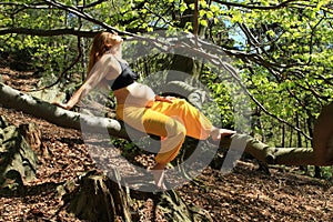 Dreaming pregnant woman sitting on branch