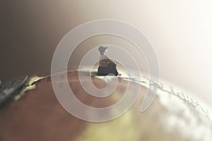 Dreaming woman looks at the infinite sitting on a giant globe