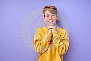 Dreaming. young Caucasian boy isolated on purple studio background. Concept of human emotion