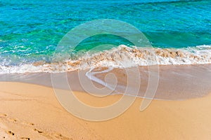 Waves on sand beach with clear blue sea water surf