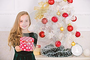 Dreams come true. Best for our kids. Kid girl near christmas tree hold gift box. Child celebrate christmas at home