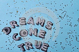 Dreams come true inscription lettering with sequins.