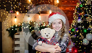 Dreams come true. Kid near christmas tree hold teddy bear soft toy. Childhood memories. Girl satisfied christmas gift