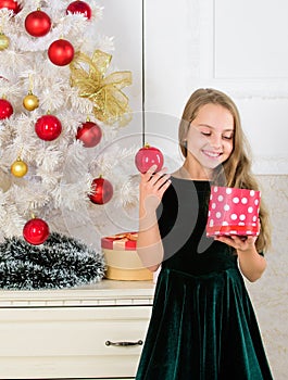 Dreams come true. Surprise concept. Kid girl near christmas tree hold gift box. Child celebrate christmas at home