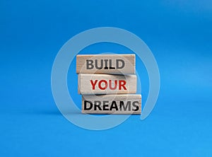 Dreams symbol. Concept word Build your Dreams on wooden blocks. Beautiful blue background. Business and Build your Dreams concept