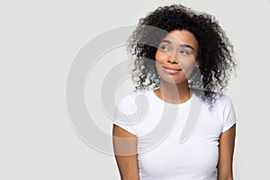 Dreamy african girl pose aside over grey blank background photo