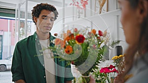 Dreamy african man smell flowers composition. Young man enjoy floral bouquet.