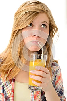 Dreamy blonde girl sipping orange juice