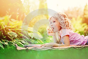 Dreamy child girl reading book in summer garden