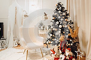 Dreamy christmas decor photo corner with gifts, lights and christmas tree