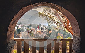 dreamy city landscape dawn town in warm autumn morning lights through balcony stone arch background