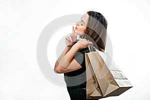 Dreamy cute girl with shopping paper bags posing on white background