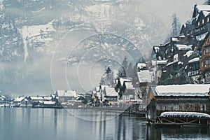 Dreamy European village on a lake covered by fog and romantic and mysterious winter.