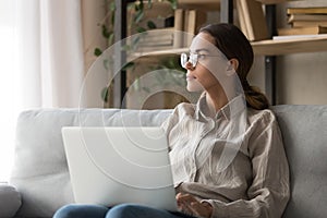 Dreamy female look in distance distracted from computer work