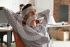 Dreamy happy indian businesswoman relaxing taking break at work