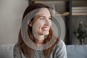 Dreamy happy millennial caucasian woman looking at distance.