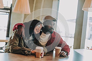 Dreamy lady putting head on the shoulder of her boyfriend and relaxing in cafe