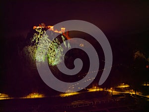 Dreamy Lake Bled with illuminated Bled castle and walkway at night in winter