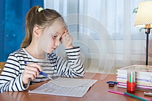 Dreamy little girl sit at desk studying look in distance visualizing or thinking, small child dreamer feel unmotivated distracted