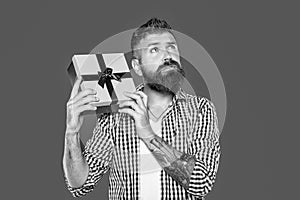 dreamy mature bearded man with present box on grey background