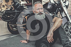 Dreamy old man locating near motorcycle