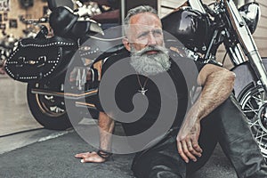 Dreamy old man locating near motorcycle photo