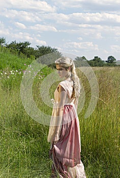 Dreamy portrait of bohemian blonde girl in field of grass