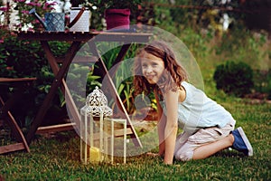 Dreamy romantic kid girl relaxing in evening summer garden