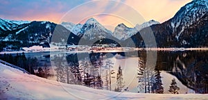 Dreamy sunset mood at lake Achensee, view to pertisau tourist resort and snowy alps