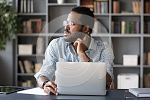 Dreamy thoughtful African American businessman looking to aside