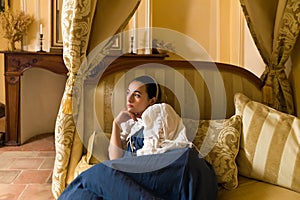 Dreamy woman in antique canopy bedroom