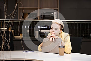 Dreamy woman working laptop in the office