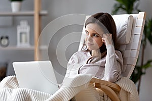 Dreamy woman writer sitting in chair thinking of new idea photo