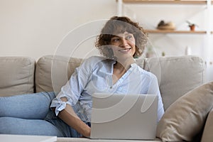 Dreamy young 35s woman using computer at home.