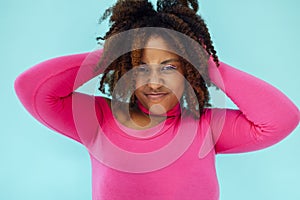 Dreamy young beautiful African American woman with bright eyelines wearing pink bodysuit