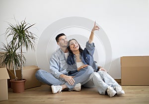 Dreamy young couple planning interior design after moving home