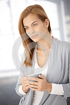 Dreamy young woman with coffee mug