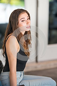 Dreamy young woman relaxing outdoors glancing away from camera