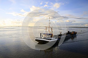 Dredger vessel in the Wadden Sea preventing the fairway from silting up