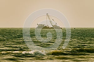 Dredger working at sea. Ship excavating material from a water environment