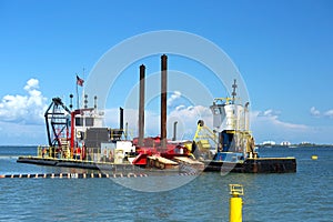 Dredging and multi purpose boat work together on the Gulf of Mexico photo