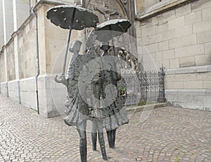 Drei Damen mit Regenschirm mit dem Titel Aachener Wetter, Bronzeskulptur