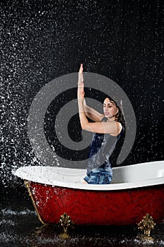 Drenched girl protected from the water stands in